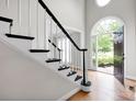 Welcoming foyer with wood floors, staircase and arched window providing natural light at 12711 Duncourtney Ln, Charlotte, NC 28277