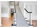 Stylish staircase with herringbone carpet runner, contrasting dark handrail, and open floor plan at 12711 Duncourtney Ln, Charlotte, NC 28277