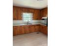 Cozy kitchen features wood cabinets, light countertops, and stainless steel sink under a window at 1412 Beverly Ave, Shelby, NC 28152