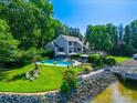 A captivating backyard featuring a sparkling pool, lush landscaping, and water access at 15 Old Stage Trl, Clover, SC 29710