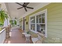 Inviting front porch with a ceiling fan, comfortable seating and views of the landscaped front yard at 1500 Lynway Dr, Charlotte, NC 28203