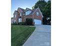 Brick home featuring an attached garage, basketball hoop, and well-maintained lawn at 15737 Agincourt Dr, Huntersville, NC 28078