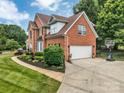 Brick home with a two-car garage, well-maintained landscaping, and a paved driveway with a basketball hoop at 15737 Agincourt Dr, Huntersville, NC 28078