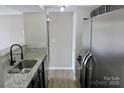 The updated kitchen features granite countertops, stainless steel appliances, and a sink with black faucet at 1604 Arlyn Cir # E, Charlotte, NC 28213