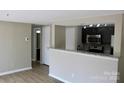 Open living space with laminate floors and view of the kitchen with granite countertops at 1604 Arlyn Cir # E, Charlotte, NC 28213