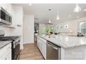 Bright kitchen features a granite island with pendant lighting and stainless steel appliances at 1659 Loggerhead Dr, Lancaster, SC 29720