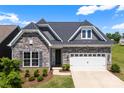 Beautiful stone and siding exterior with a two car garage, manicured shrubs and lawn at 19004 Dry Narrows Way, Charlotte, NC 28278