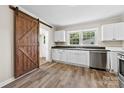 Bright kitchen featuring white cabinets, stainless steel appliances, and a sliding barn door at 2009 Auten Rd, Gastonia, NC 28054