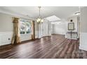 Open living area with hardwood floors, chandelier, a window, and elegant trim details at 2028 Covered Bridge Ct, Rock Hill, SC 29732