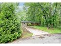 A well-maintained house on a lot with a long driveway, surrounded by lush greenery at 205 E Cleveland Ave, Bessemer City, NC 28016