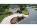 Aerial view of home with well-maintained landscaping, gravel driveway, and lush green surroundings at 212 Old Centergrove Rd, Kannapolis, NC 28083