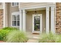 Inviting front porch with white columns, manicured greenery, and a decorative welcome mat at 228 Dawn Mist Ln, Fort Mill, SC 29708