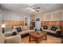 Inviting living room with wood paneling, comfortable seating and a ceiling fan and exterior door at 3 Circle Dr, Lincolnton, NC 28092