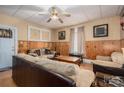 Cozy living room with wood paneling, ceiling fan, neutral-colored furniture and a door leading outside at 3 Circle Dr, Lincolnton, NC 28092