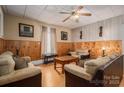 Comfortable living room with wood paneling, ceiling fan and neutral colored furniture set at 3 Circle Dr, Lincolnton, NC 28092
