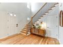 Bright foyer with hardwood floors, staircase, and a wooden accent cabinet for storage at 319 S San Agustin Dr, Mooresville, NC 28117