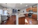 Stylish kitchen with granite counters, stainless appliances, and hardwood floors seamlessly flowing into the living area at 3342 Yarmouth Ln, Gastonia, NC 28056
