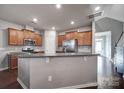 Open kitchen featuring granite countertops, stainless steel appliances, and rich hardwood flooring at 3342 Yarmouth Ln, Gastonia, NC 28056