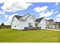 Well-maintained home boasting lush green lawn, white siding, and a convenient two-car garage at 3924 Dahlia Dr, Harrisburg, NC 28075