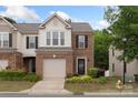 Charming brick-front townhome with a one-car garage and beautifully landscaped front yard at 4278 Park South Station Blvd, Charlotte, NC 28210