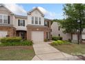 Brick-front townhome with a one-car garage, mature landscaping, and a well-maintained lawn at 4278 Park South Station Blvd, Charlotte, NC 28210