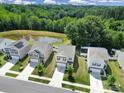 Aerial view of homes near a peaceful pond with lush surrounding trees and well-kept lawns at 461 Misty Law Ln, Clover, SC 29710