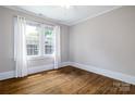 Bright bedroom with hardwood floors and natural light streaming through large windows at 524 Hawthorne Ln, Charlotte, NC 28204