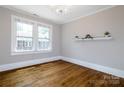 Bright room featuring hardwood floors, white trim, and a chandelier, bathed in natural light from large windows at 524 Hawthorne Ln, Charlotte, NC 28204