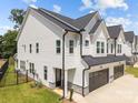 Side view of a modern home with white siding, black roof, and well-manicured lawn at 6032 Corbin Woods Ct, Charlotte, NC 28226