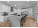 A modern kitchen featuring sleek white cabinetry, a large island, and stainless steel appliances at 6032 Corbin Woods Ct, Charlotte, NC 28226