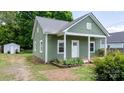 Charming green home featuring a cozy front porch with bright white trim at 639 S Eastway Dr, Troutman, NC 28166