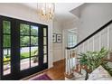 Bright foyer with a stylish light fixture and hardwood flooring leading to the staircase at 6409 Ilex Ct, Charlotte, NC 28211