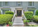 Inviting front entrance featuring a classic painted brick facade and landscaped steps at 6409 Ilex Ct, Charlotte, NC 28211