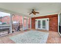 Inviting screened porch with a red brick wall, double doors, and decorative outdoor rug at 6908 Lancer Dr, Charlotte, NC 28226