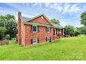 Classic brick home with a chimney and manicured lawn in a suburban setting at 6908 Lancer Dr, Charlotte, NC 28226