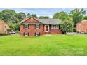 Charming brick home with a well-maintained lawn and a vibrant red front door at 6908 Lancer Dr, Charlotte, NC 28226