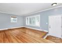 Bright, empty living room with hardwood floors, large windows, and fresh paint at 6908 Lancer Dr, Charlotte, NC 28226