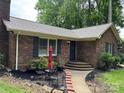 Brick home featuring a well-maintained lawn, classic shutters, and inviting front entryway at 7316 Truelight Church Rd, Mint Hill, NC 28227