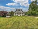 Beautiful home with manicured lawn and garden featuring a charming gazebo at 735 Davidson Run Ln, Davidson, NC 28036