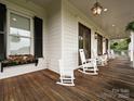 Charming front porch with rocking chairs, wood flooring and detailed trim at 735 Davidson Run Ln, Davidson, NC 28036