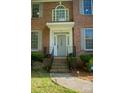 Close up of the front door with brick steps, wrought iron railing, sidelights and half-round transom at 7708 Harrington Woods Rd, Charlotte, NC 28269