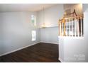 Bright living room featuring high ceilings, hardwood floors, staircase, and natural light at 7830 Shiny Meadow Ln, Charlotte, NC 28215