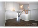 Open-concept living room with hardwood floors, staircase, and abundant natural light at 7830 Shiny Meadow Ln, Charlotte, NC 28215