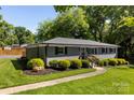 A gray brick single-story home featuring well-maintained landscaping and a charming walkway to the entrance at 7921 Willhill Rd, Mint Hill, NC 28227