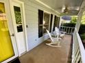 Cozy front porch featuring a ceiling fan, black window shutters, and two white rocking chairs at 8742 Rittenhouse Cir, Charlotte, NC 28270