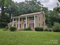Two-story brick house with columns, red shutters, chimney, and a large lawn at 9225 Robinson Church Rd, Charlotte, NC 28215