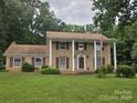 Beautiful two-story brick house with a porch, pillars, red shutters, and a large grassy front yard at 9225 Robinson Church Rd, Charlotte, NC 28215