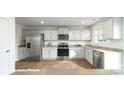 Well-lit kitchen featuring stainless steel appliances, gray cabinets, granite countertops, and wood-look flooring at 1037 20Th Avenue Se Loop, Hickory, NC 28602