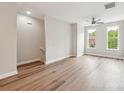Open living area with hardwood floors, staircase, and large windows showcases bright, neutral color palette at 1126 Dean Hall Ln, Matthews, NC 28105