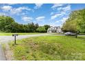 A farmhouse-style house on a grassy lot with a long driveway and mature trees at 12504 Culp Rd, Gold Hill, NC 28071